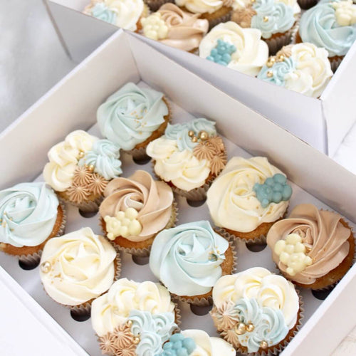 Cute cupcakes dekoreret med fløjlsblød topping, sprøjtet i rosetter og kombinerede dekorationer. Blå udgave